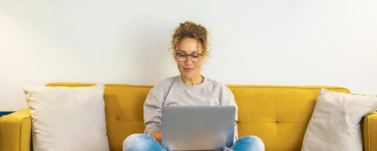 Une femme consulte les changements du coup de pouce rénovation performante sur son ordinateur