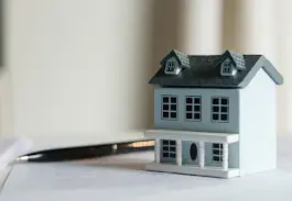 maquette d'une maison à côté d'un stylo