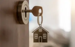 porte clé maison accroché à une paire de clé d'une maison