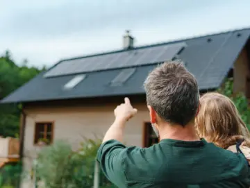 des hommes installent des panneaux solaires sur un toit