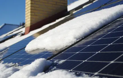 panneau solaire sur un toit recouvert de neige blanche