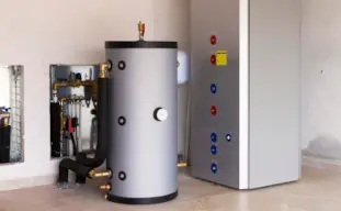 unité intérieure d'une pompe à chaleur blanche sur un mur gris avec une main qui tient la télécommmande