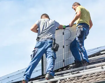 deux hommes qui installent des panneaux solaires