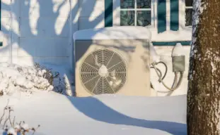 unité extérieure d'une pompe à chaleur dans la neige