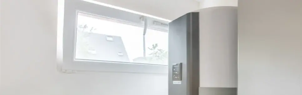 chauffe eau thermodynamique gris dans une salle avec une fenêtre rectangulaire