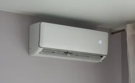 unité intérieure d'une pompe à chaleur air/air sur un mur gris
