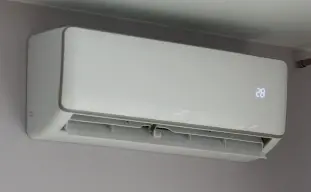 unité intérieure d'une pompe à chaleur air/air sur un mur gris