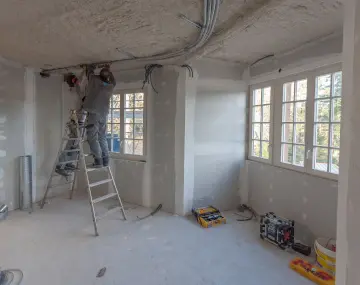 L'intérieur d'une maison en rénovation énergétique globale avec deux ouvriers