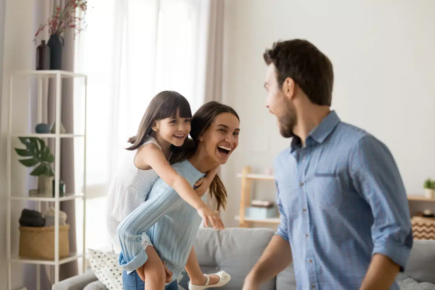 Une mère, un père et leur fille qui jouent dans le salon